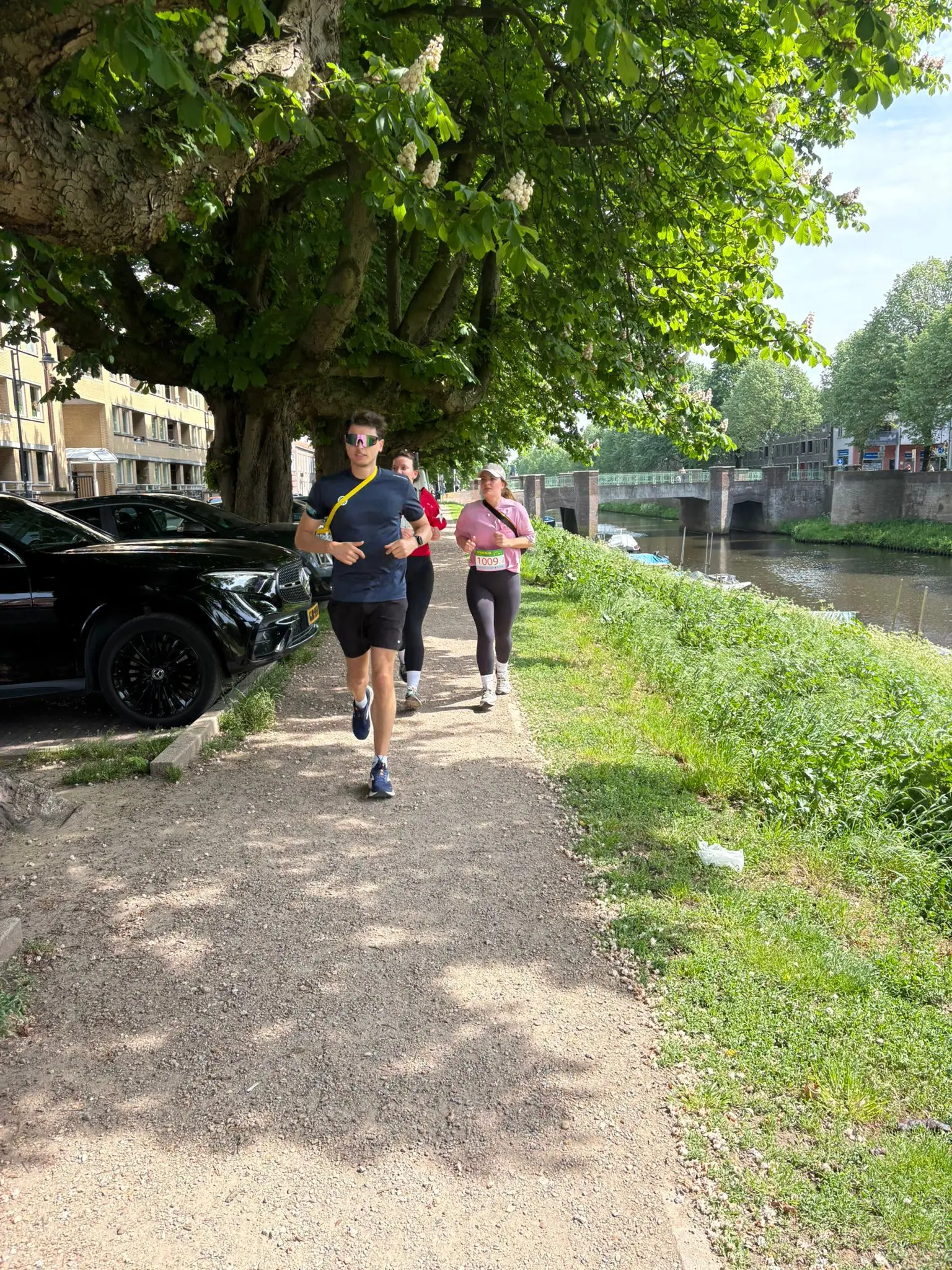 Deelnemers aan de Bossche Oranje Run langs het water in Den Bosch